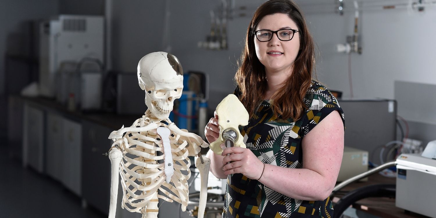 Dr Kathryn Fee by an anotomical skeleton at Queens University.